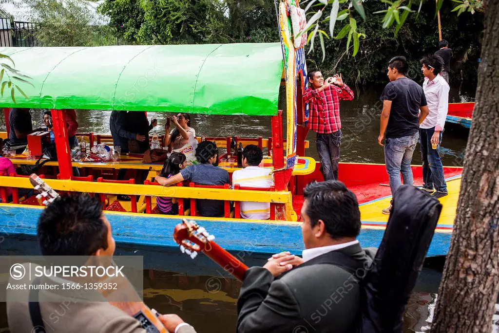 Musicians waiting to be hired and Trajineras on Canal, Xochimilco, Mexico City, Mexico.