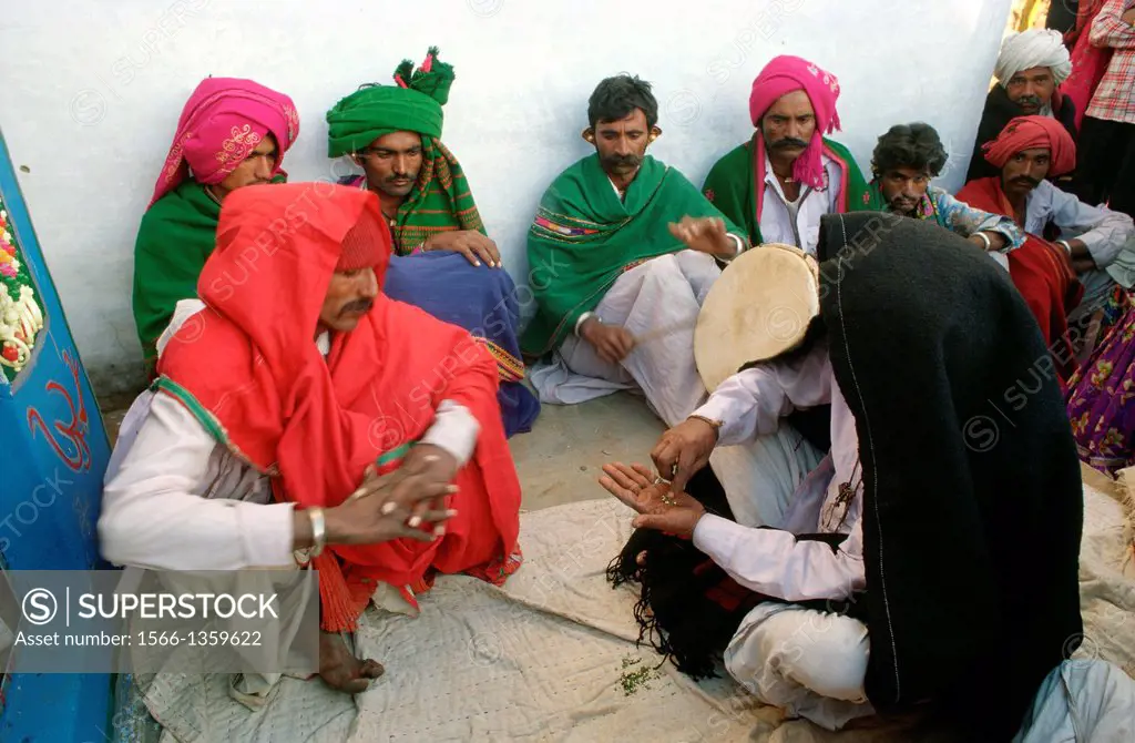 Propitiatory ritual performed by a traditional healer ( the man under the black blanket) among the Rabari caste. Kachchh region, India.