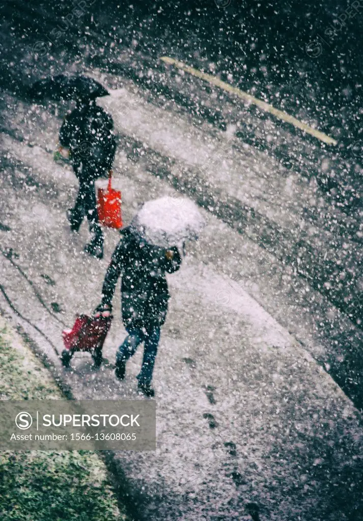 two persons passing each other on the street in heavy snowfall, winter in Geneva, Switzerland, Europe