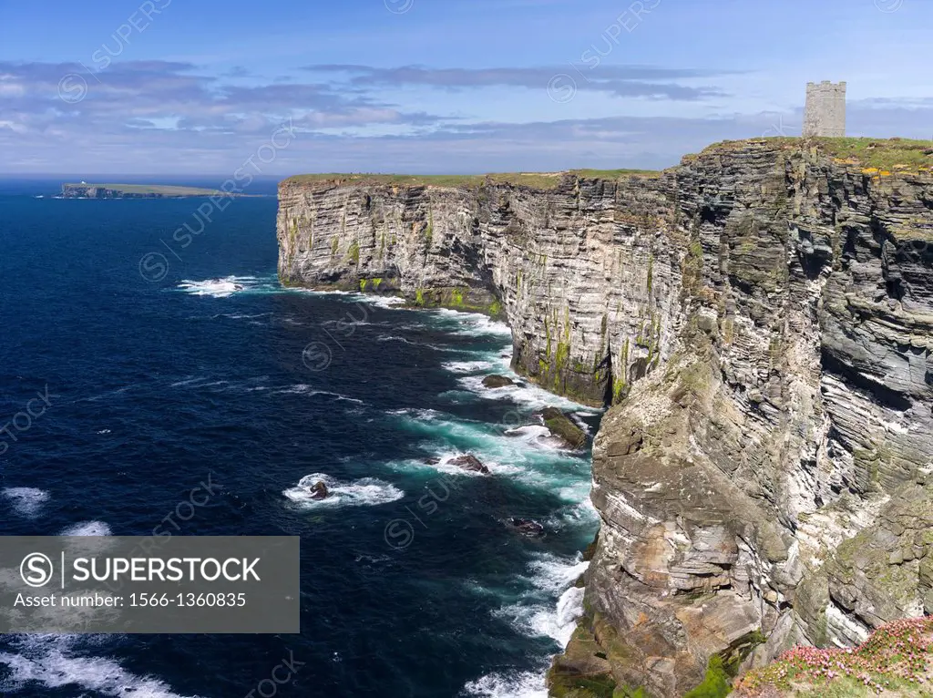 The Cliffs of Marwick Head, Orkney Mainland. In the background the Brough of Birsay, on the cliffs is Kitchener's Memorial, commemorating his death, w...