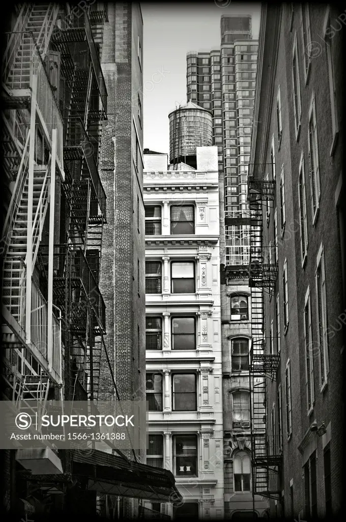 Iron fire escape stairs and balconys on the facade of a building in SoHo RE of New York City.