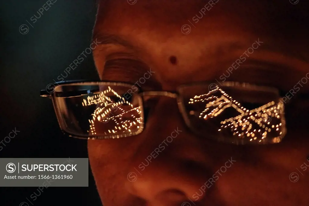 Woman´s face with spectacles reflecting Diyas in diwali Festival, India