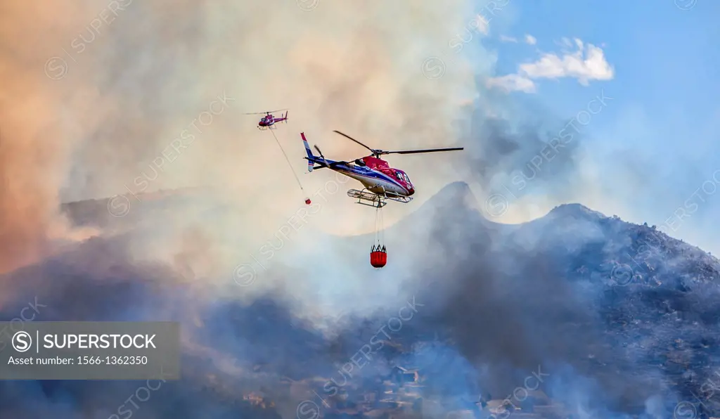 Two helicopters hauling water buckets to fight fire, South Jordan, Utah, USA