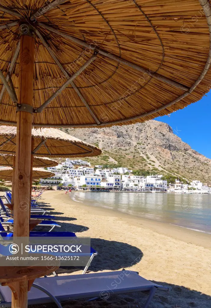 Sun shades and sun loungers on Kamares Beach, Kamares Town, Sifnos, Cyclades, Greece.