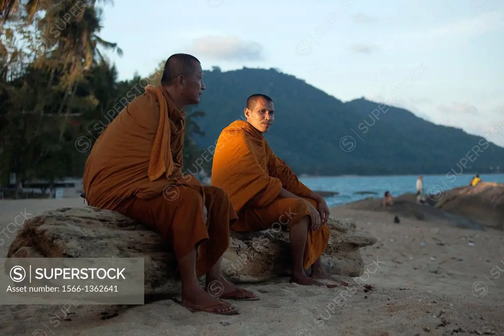 Two monks resting on the beach; Lamai Beach; Koh Samui; Surat Thani Province, Thailand.