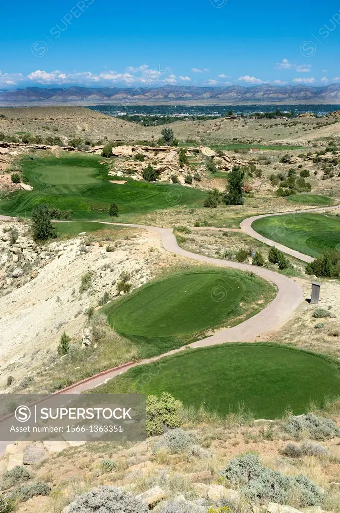 Seventeenth green and fairway at Redlands Mesa Golf Club, Grand Junction, Colorado, USA with the Little Book Cliff Mountain Range in the distance.