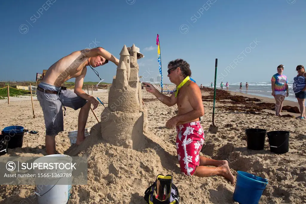 South Padre Island, Texas - Master sand castle sculptors demonstrate their techniques at the beginning of a sand castle building contest.