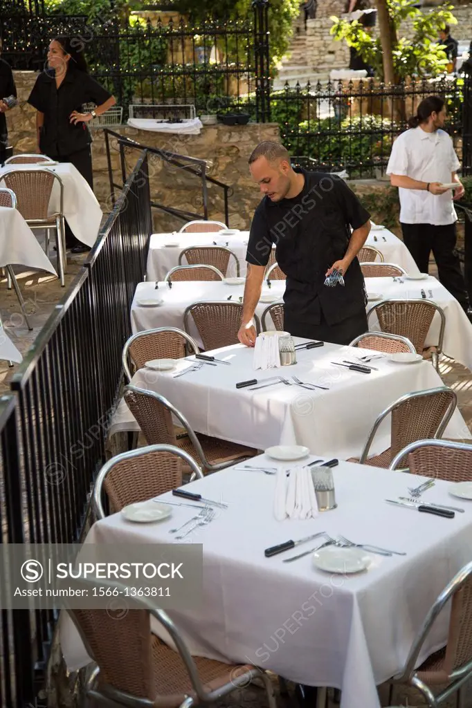 San Antonio, Texas - A waiter sets tables for dinner in a restaurant on the Riverwalk.