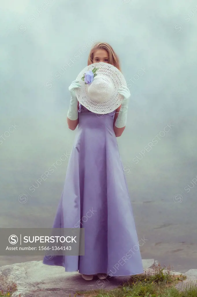 a beautiful young woman is hiding behind a white sun hat.