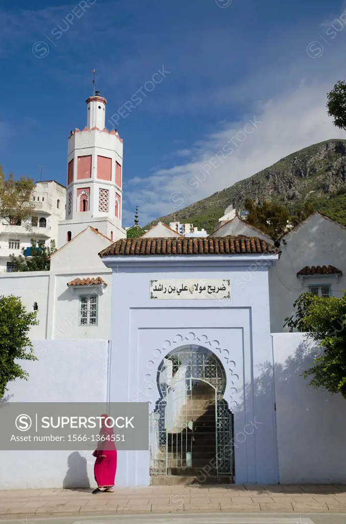 An Arab woman walks past mosque in Chefchaouen, Morocco.