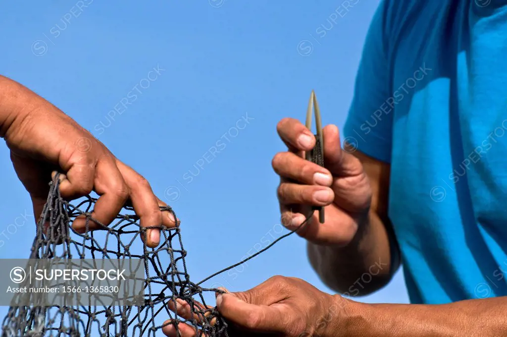 Fisherman repairing trawl net, Bellingham, Washington USA.