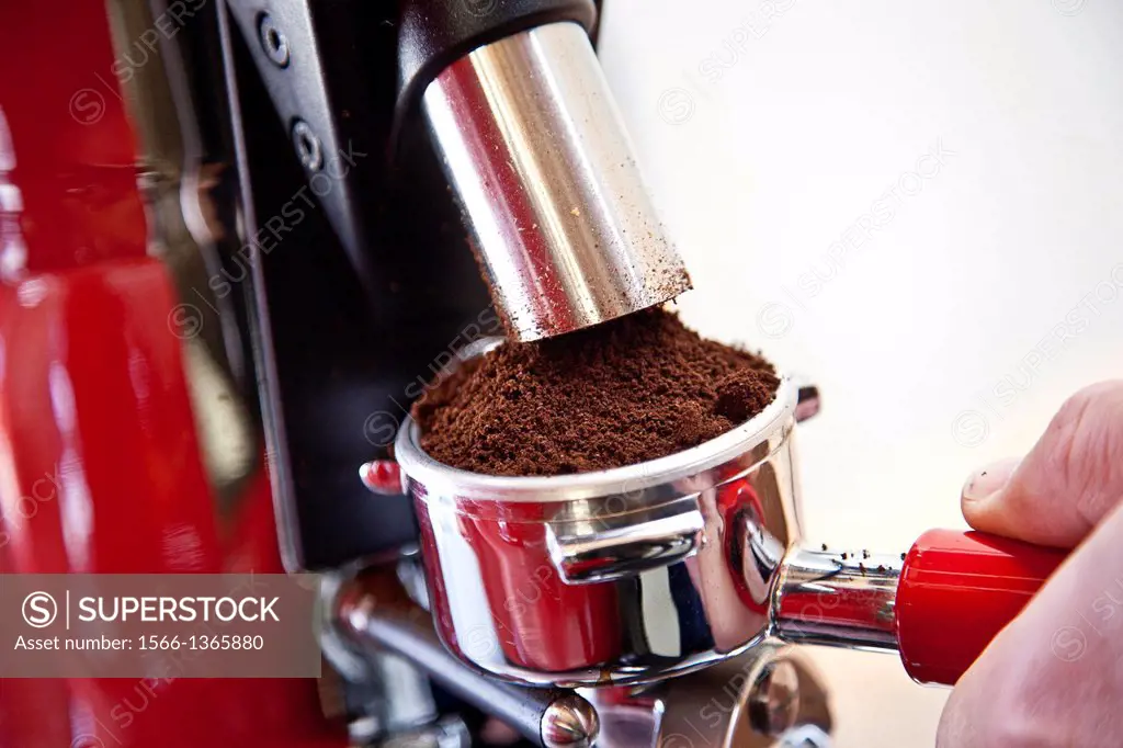 Person making fresh coffee with expresso machine.