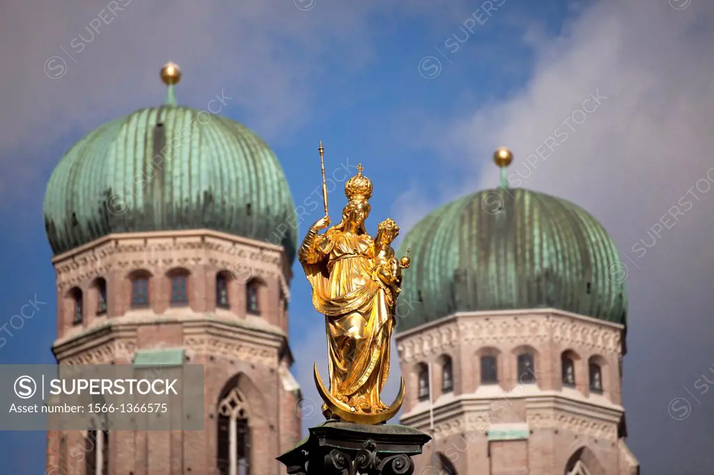 Virgin Mary atop the Mariensaeule and the church towers of the Frauenkirche in Munich, Bavaria, Germany.