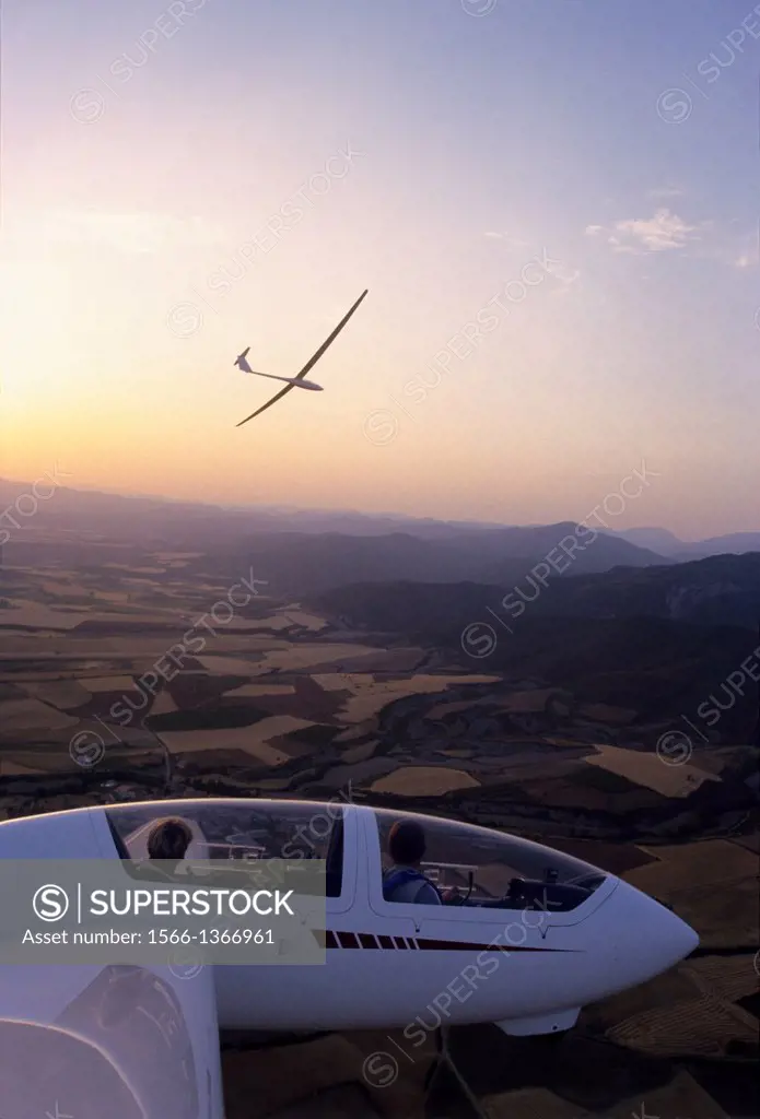 Glider planes Twin Astir and ASH-25 flying on sunset near Santa Cilia de Jaca, Aragon, Spain.