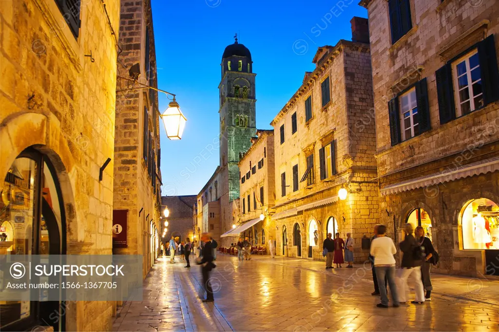 Looking West down the Stradun square towards pile gate and the Franciscan bell tower at night with shiny marble street surface, old town Dubrovnik. Cr...