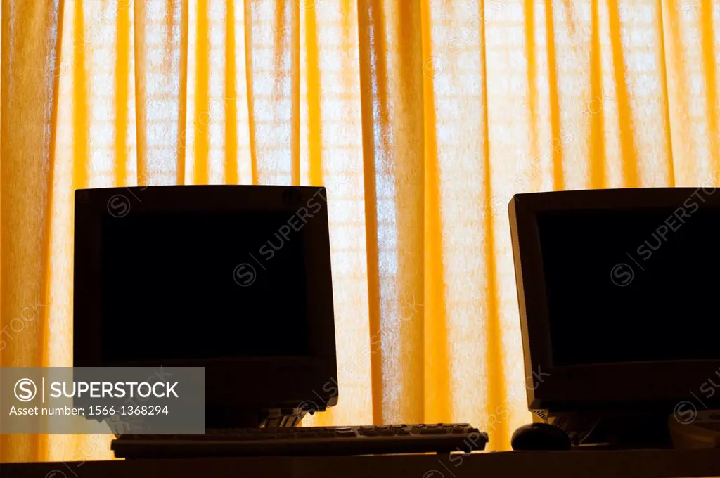 computer screens on yellow curtains.