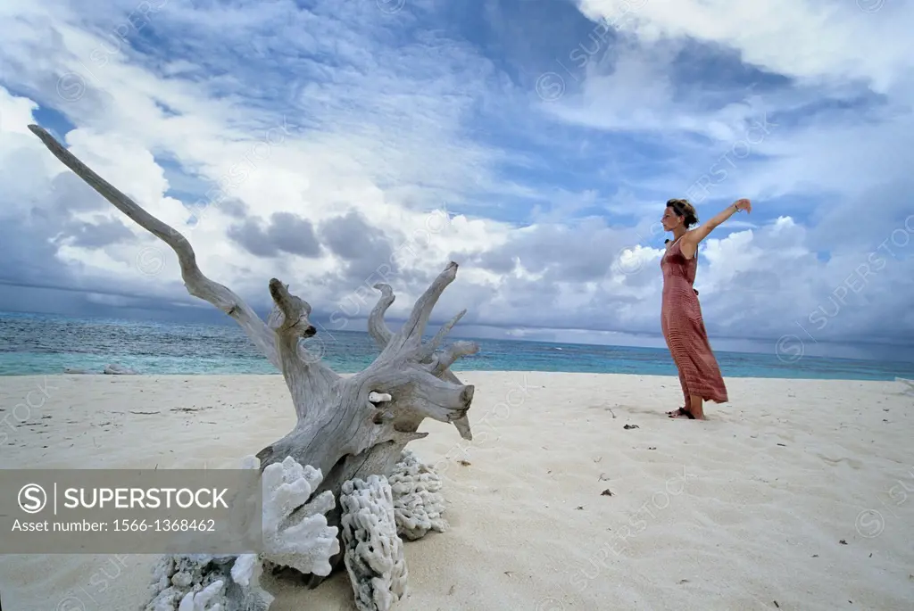 young woman relaxing on a beach of Denis island, Republic of Seychelles, Indian Ocean