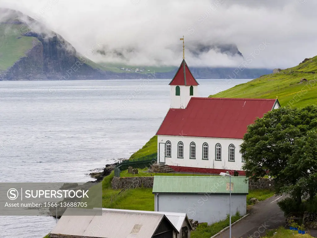 The island of Kunoy with village Kunoy and church. In the background island Kalsoy. Nordoyggjar (Northern Isles) in the Faroe Islands, an archipelago ...