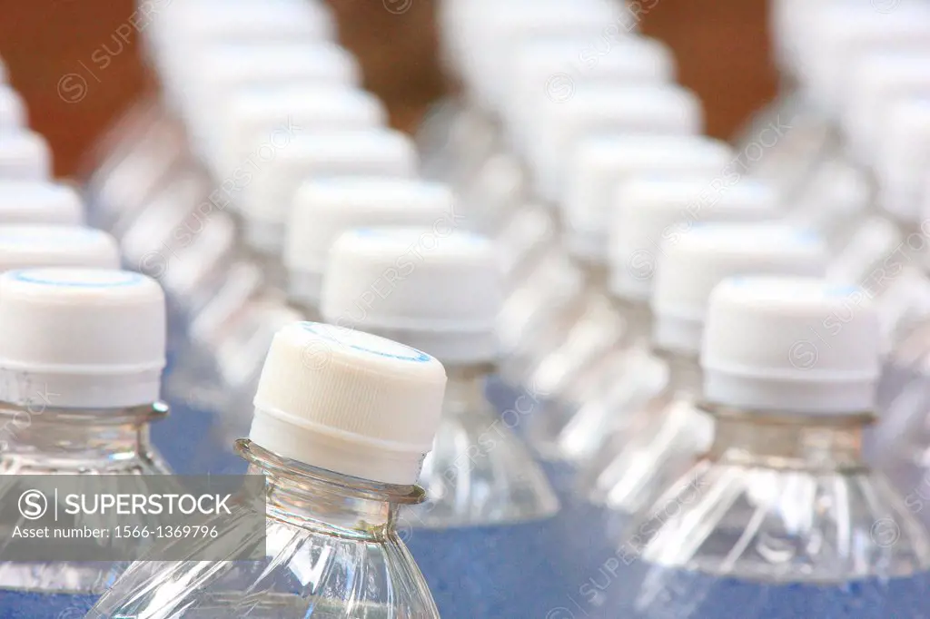 Four rows of plastic water bottles in neat lines, with one bottle in front slightly out of place, Florida, USA.