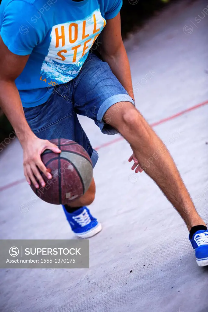 young adult playing basketball.