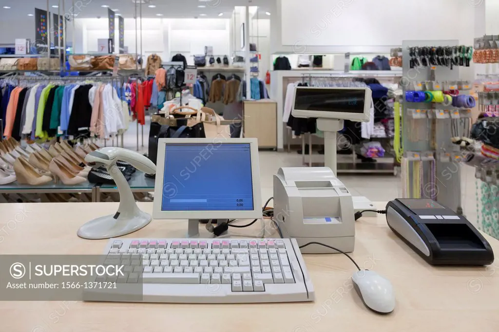 Fashion clothing store. Cashier register, scanner, computer on sales counter in shop.