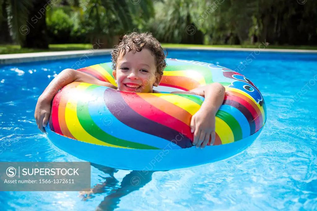Young boy enjoys summer in the pool.