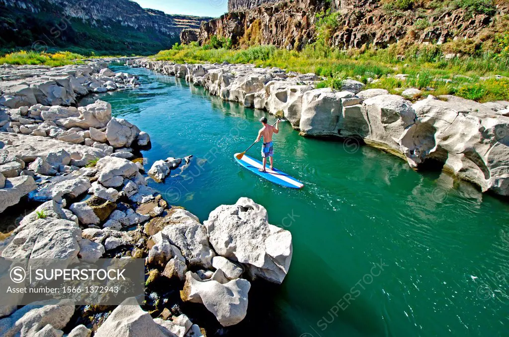 Riding the Stand Up Paddle Board on the Snake River above Twin Falls and the Idaho Connection Wave in the Snake River Canyon near the city of Twin Fal...