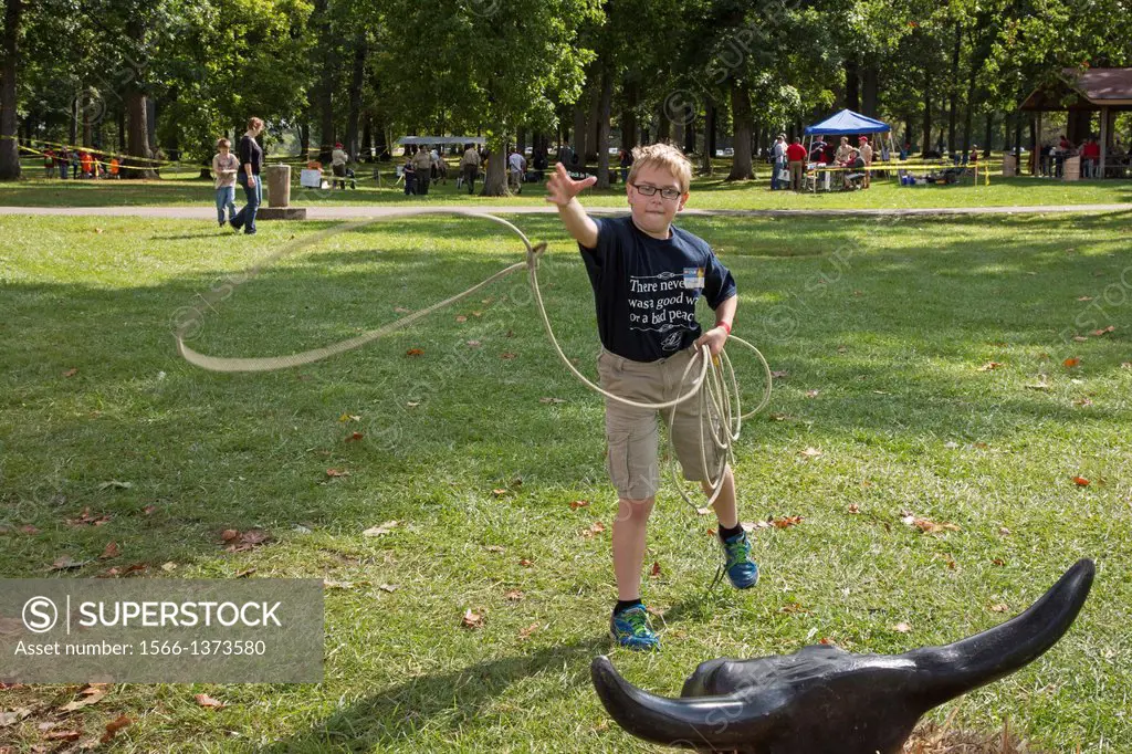 New Boston, Michigan - A Boy Scout tries to lasso the horns of a bull during a Scout gathering in a suburban Detroit park.