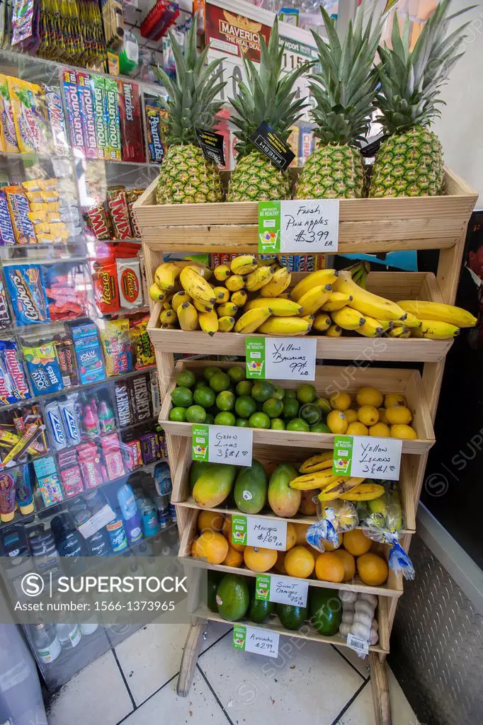 A display of fresh fruits and vegetables, surrounded by unhealthy snacks, in the Makey Deli in the South Bronx in New York. A program of City Harvest ...