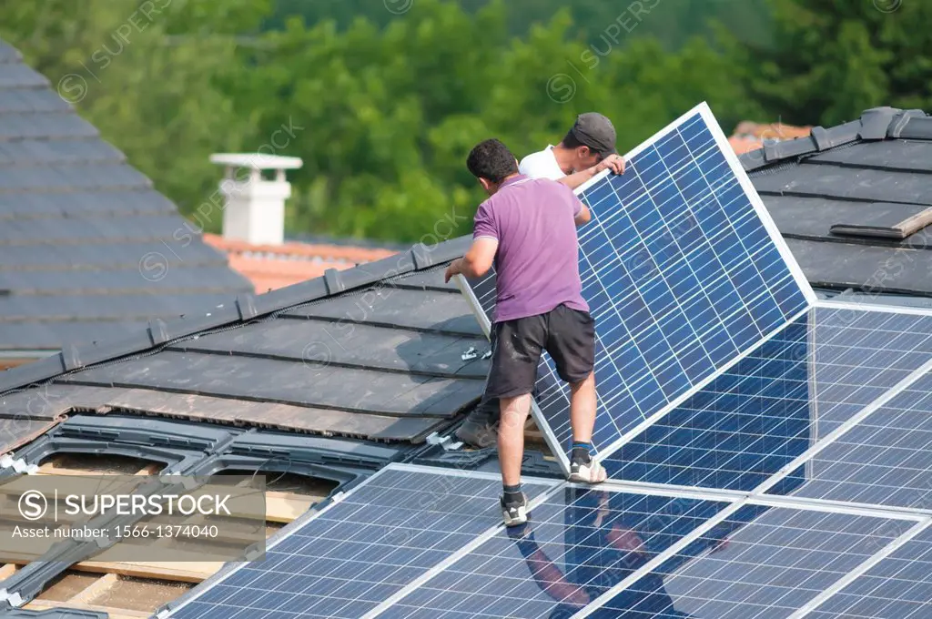 Installation of photovoltaic solar panels on roof of house, Germany.