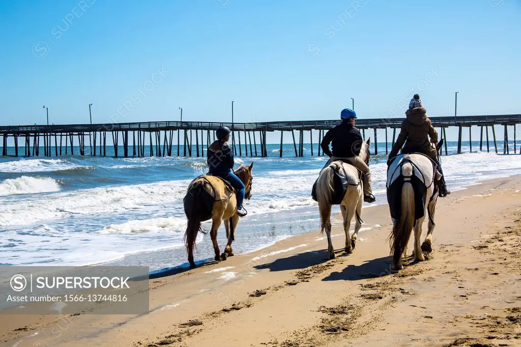 Virginia Beach boardwalk along the ocean, where people can ride horses on the beach.