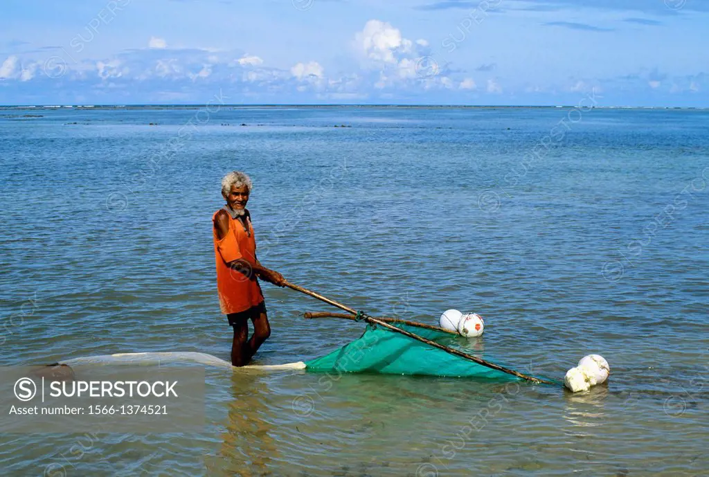 INDONESIA, SAWU (SEBA) ISLAND FISHERMAN SCOOPING NET OVER BOTTOM IN SHALLOW WATER.