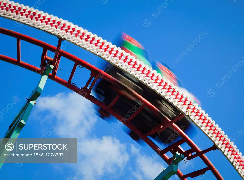 A rollercoaster cart racing down the track at an amusement park.