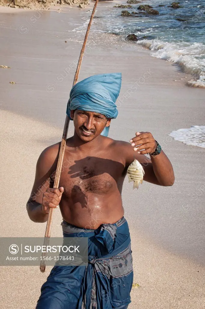 Stilt fisherman holding a fish, Koggala, Sri Lanka, Indian Ocean, Asia.