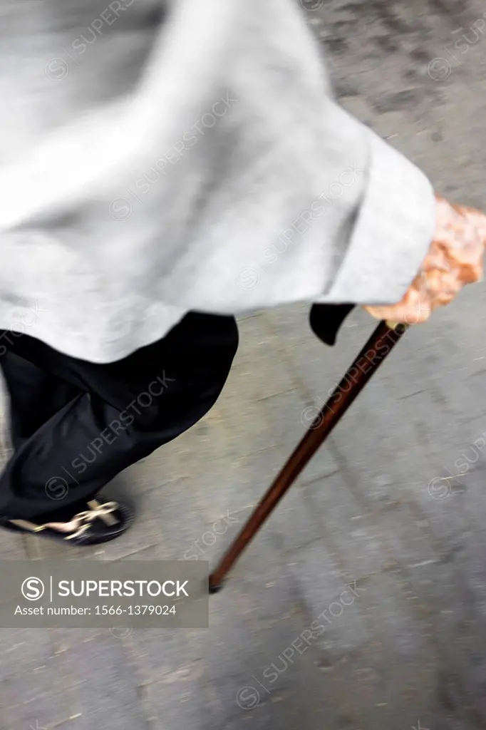 old woman walking with a cane.