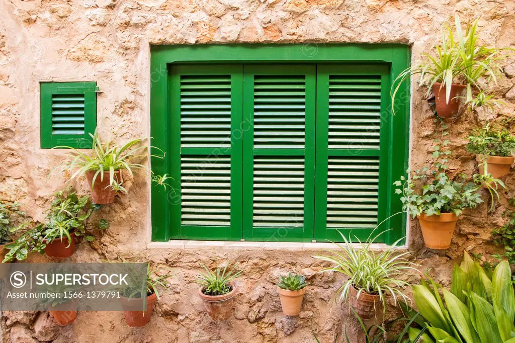 Flower pots on the walls of the typical street of Valldemossa village, Mallorca.