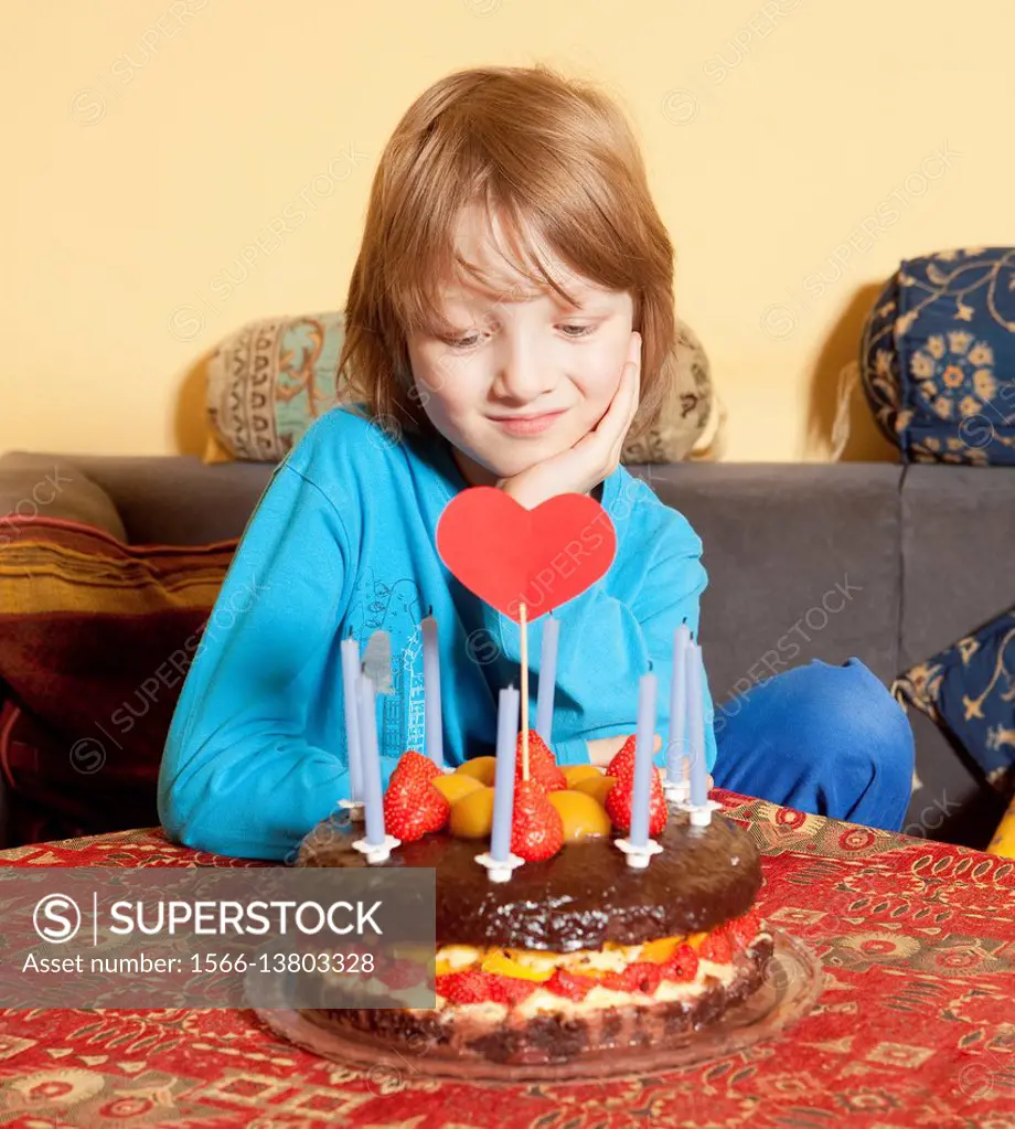 Boy with Blond Hair Looking at his Birthday Cake.