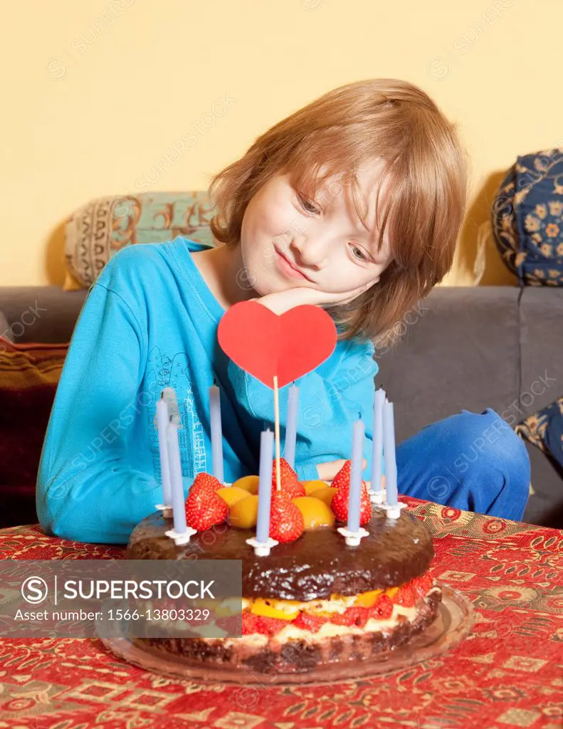 Boy with Blond Hair Looking at his Birthday Cake.