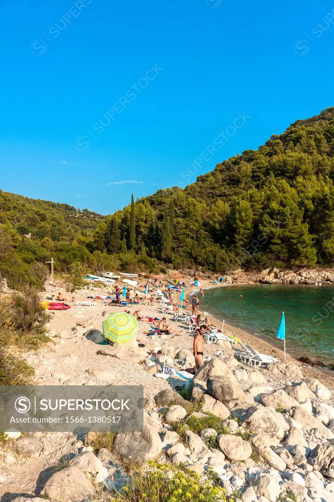 Tourists relaxing on Pupnatska beach near Pupnat, Croatia.
