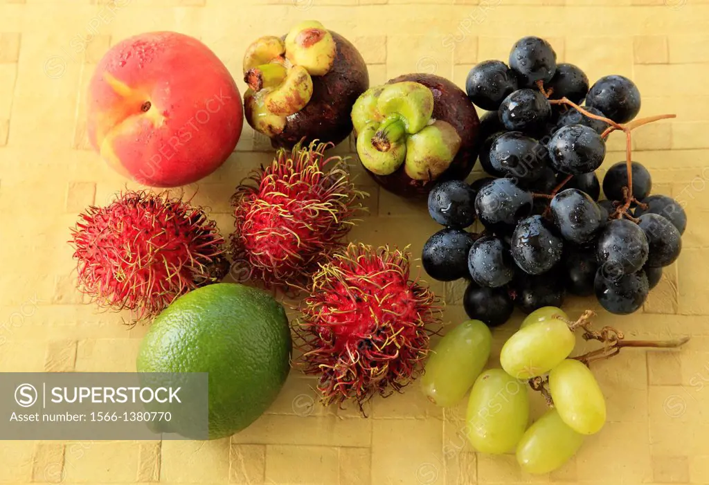 Variety of fruit display, peach, rambutan, mangosteen, lime, grapes,.