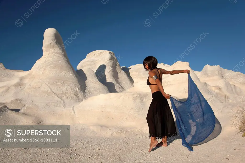 Woman posing near the white rock forms in Sarakiniko beach, Milos, Cyclades Islands, Greek Islands, Greece, Europe.