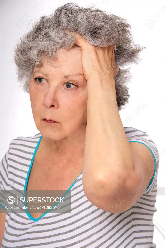 Senior woman holding her head, feeling, dizzy, or tired, or sad, suffering from depression, or from a headache