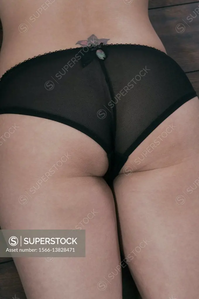 Close up rear view of a woman wearing underwear laying down on the