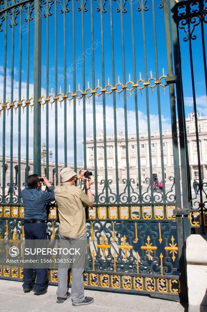 Two men taking pictures of the Royal Palace. Armeria Square, Madrid, Spain.