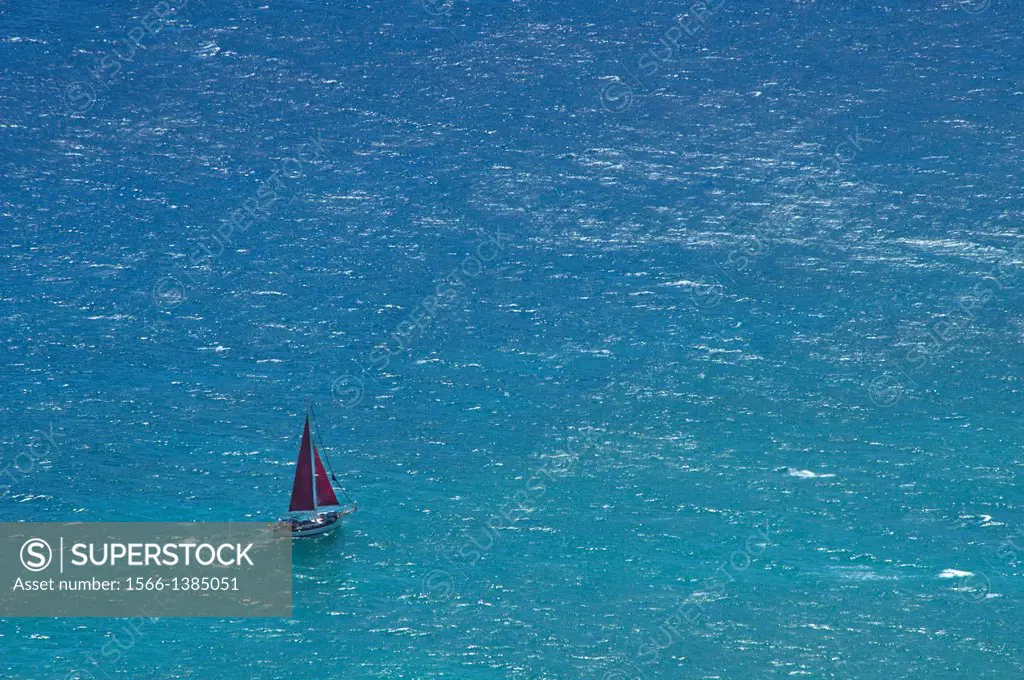 Small yacht sailing in open ocean.
