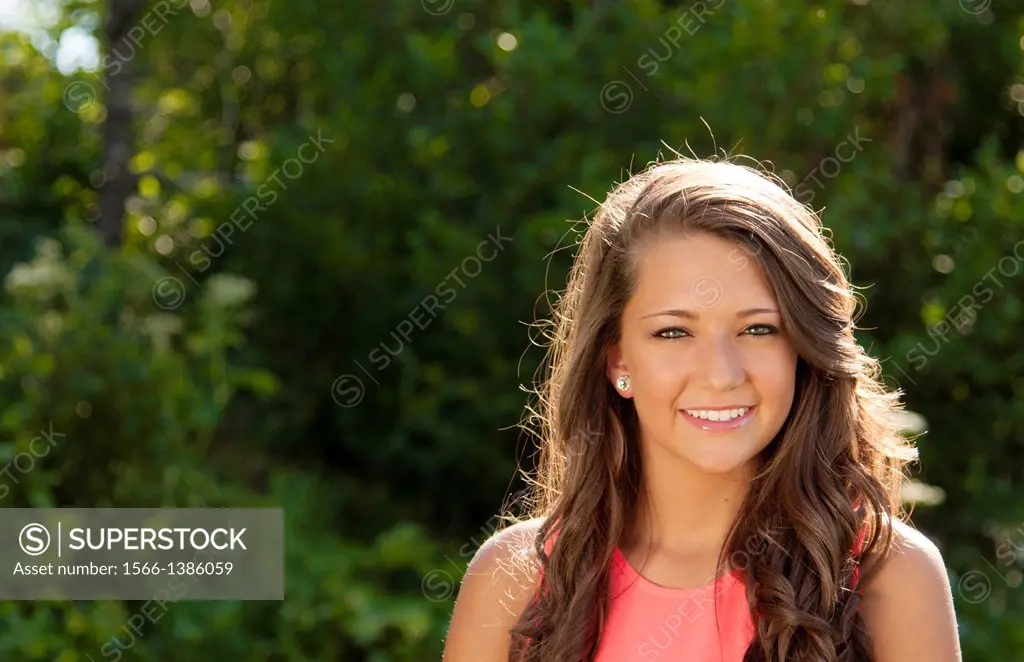 Teenager girl clean makeup smile outdoors seventeen beauty face in sunshine backlit happy teen with great hair.