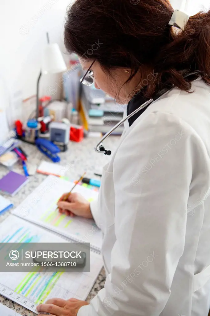 Female doctor checks her diary to screen calls patients.