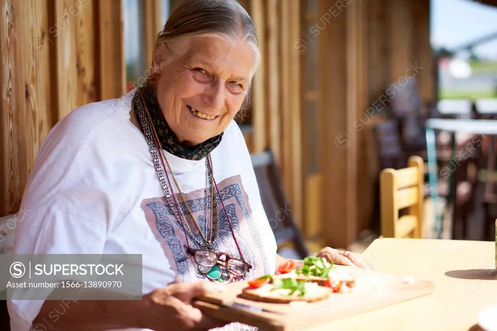 happy senior woman eating healthy bread with vegetables