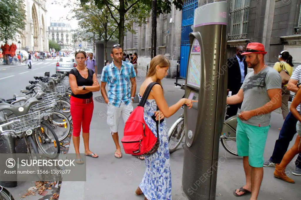France, Europe, French, Paris, 4th arrondissement, Île de la Cité, Rue d'Arcole, Velib bike share system, man, woman, couple, kiosk,.
