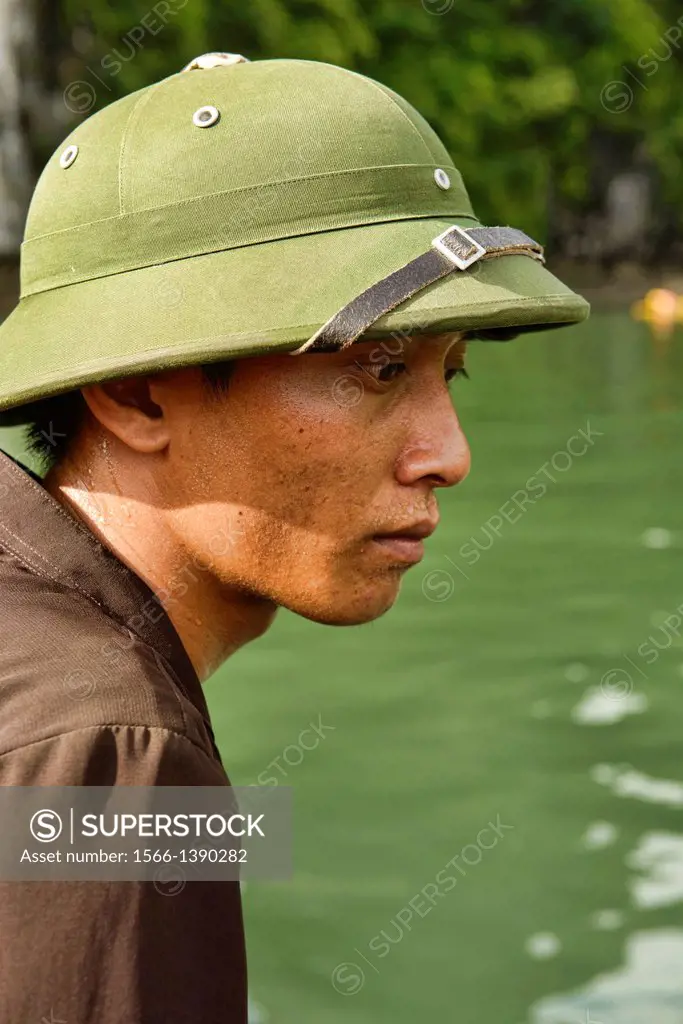 portrait of a boat driver in a pith helmet in Halong Bay, Vietnam.